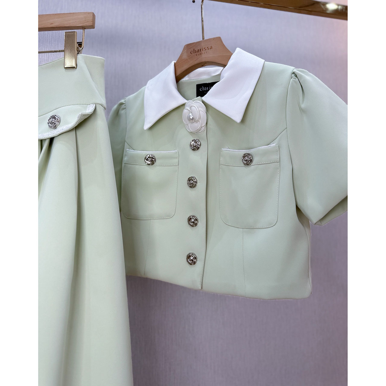 kudapy ชุดเซ็ทเสื้อทรงครอป กระดุมจริงรูปดอกไม้สีเงิน แต่งปกสีขาว มาพร้อมกับกระโปรงยาวซิปหลัง แต่งกระเป๋าหลอกด้านหน้า