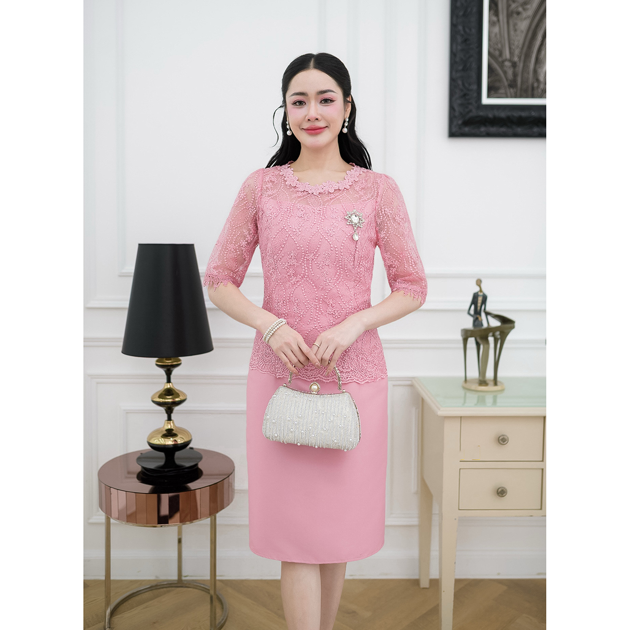 kudapy เดรสผ้าไหมทรงเรียบ ด้านบนเป็นงานผ้าลูกไม้ใยบวบแขนสามส่วนแต่งปลายแขนด้วยลูกไม้ทอลาย ช่วงคอแต่งด้วยลูกไม้ดอกไม้รอบคอ