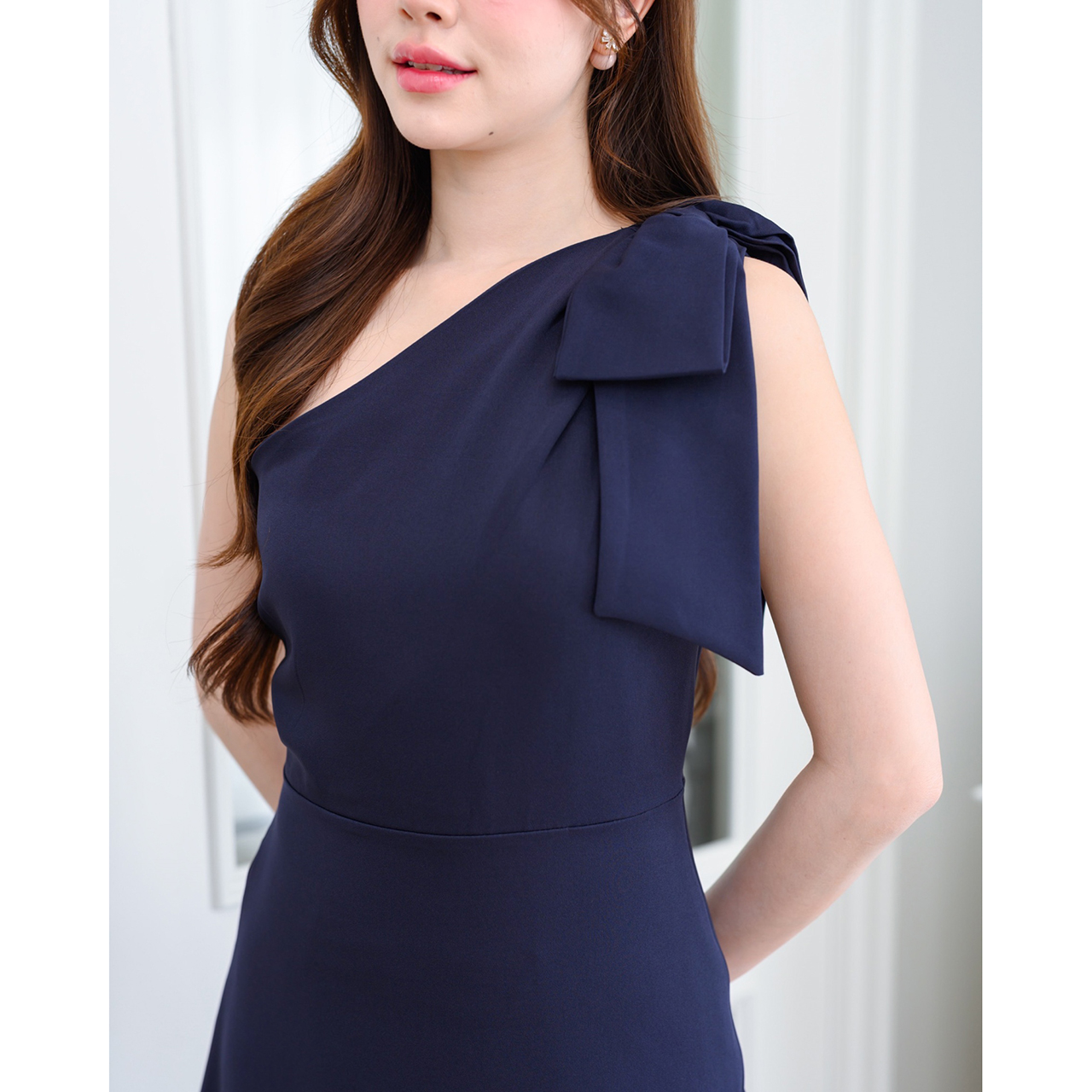 kudapy เดรสยาวสไตล์เรียบหรู ดีไซน์คอเฉีบงปาดไหล่ แต่งด้วยโบว์เพิ่มความน่ารักละมุน ทรงส่วยเข้ารูปพอดีตัว กระโปรงทรงเอยาว