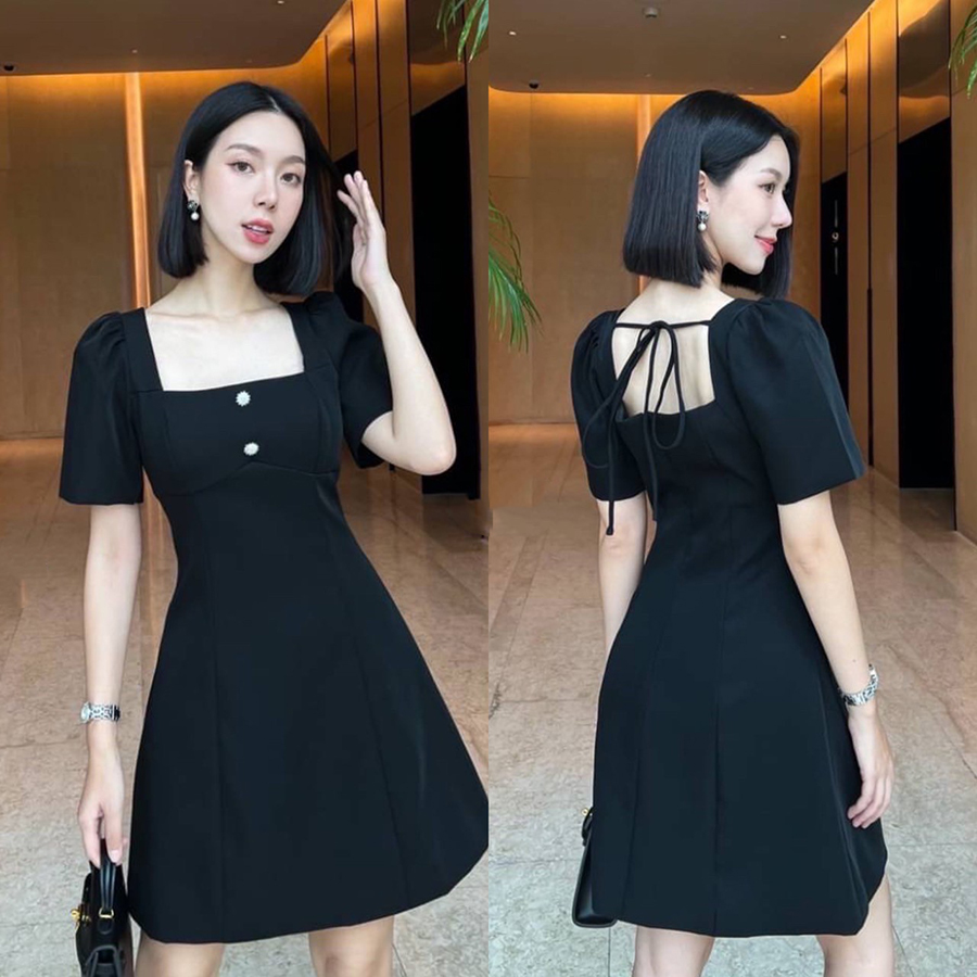 kudapy เดรสสั้นสีดำ คอเหลี่ยมด้านหน้า และหลัง เน้นความเรียบหรู ดูดี แต่งกระดุมเพชรสีเงินด้านหน้า 2 เม็ด ด้านหลังเพิ่มความกิมมิคของชุดออกแบบให้เป็นเชือกผูกเป็นโบว์ได้