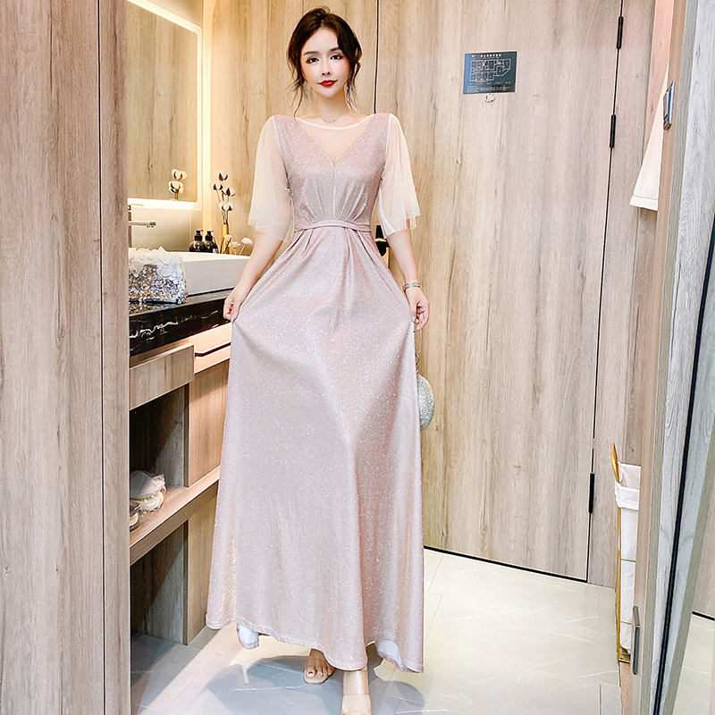 kudapy ชุดราตรียาวสีชมพูอ่อน ผ้ากลิสเตอร์ หน้าอกเสื้อแต่งด้วยผ้ามุ้งสีครีมเป็นตัววี ประดับดิ้นสีทองที่อกเสื้อติดกับผ้ามุ้ง