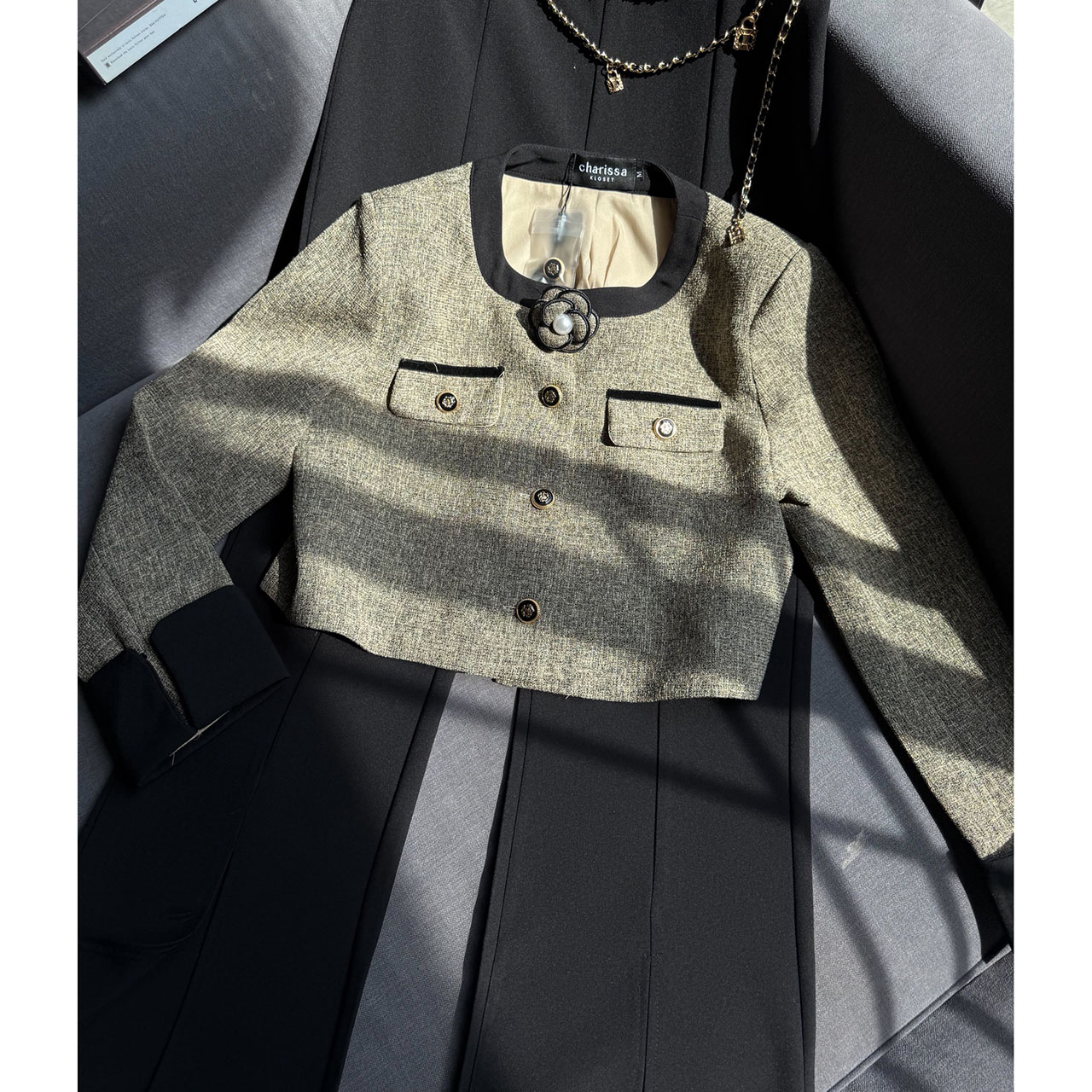 kudapy เซ็ทเสื้อครอปสูท ผ้าเนื้อทอแน่นสีสวยคลาสสิก ตัดต่อขอบสีดำบริเวณคอ แขน และชายเสื้อ เพิ่มความคมชัด กระดุมหน้าเรียงแนวตั้งแบบมินิมอล