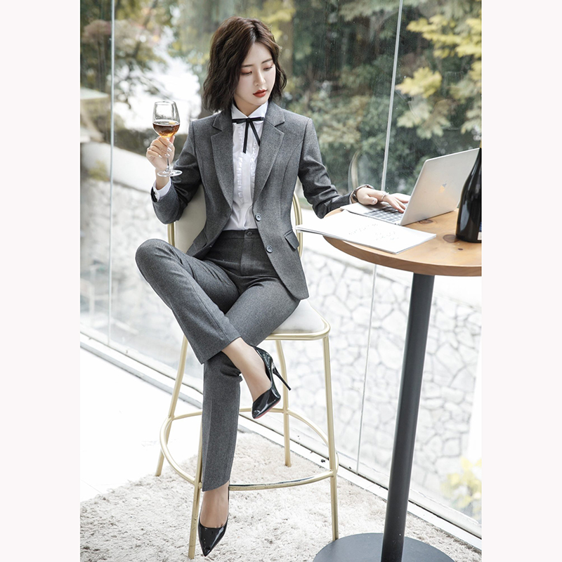 kudapy ชุดสูททำงานสีเทาเข้ม/สีฟ้าคราม แต่งกระดุมคู่พร้อมกางเกง จุดเด่นของชุดนี้คือการออกแบบตัวเสื้อที่เรียบง่ายเป็นแบบปกป้าน