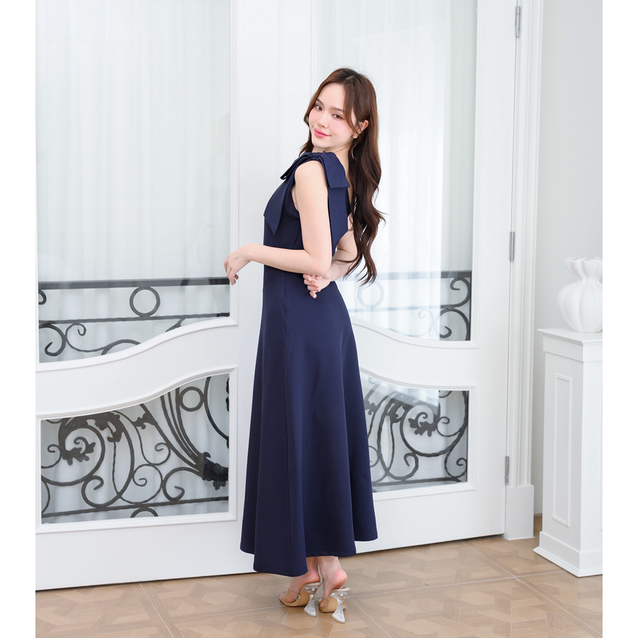 kudapy เดรสยาวสไตล์เรียบหรู ดีไซน์คอเฉีบงปาดไหล่ แต่งด้วยโบว์เพิ่มความน่ารักละมุน ทรงส่วยเข้ารูปพอดีตัว กระโปรงทรงเอยาว