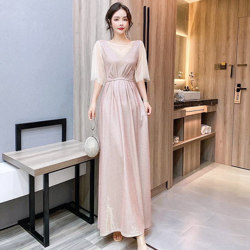 kudapy ชุดราตรียาวสีชมพูอ่อน ผ้ากลิสเตอร์ หน้าอกเสื้อแต่งด้วยผ้ามุ้งสีครีมเป็นตัววี ประดับดิ้นสีทองที่อกเสื้อติดกับผ้ามุ้ง