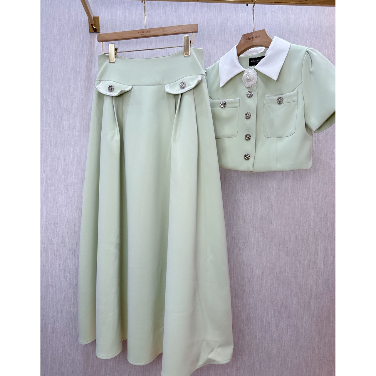 kudapy ชุดเซ็ทเสื้อทรงครอป กระดุมจริงรูปดอกไม้สีเงิน แต่งปกสีขาว มาพร้อมกับกระโปรงยาวซิปหลัง แต่งกระเป๋าหลอกด้านหน้า