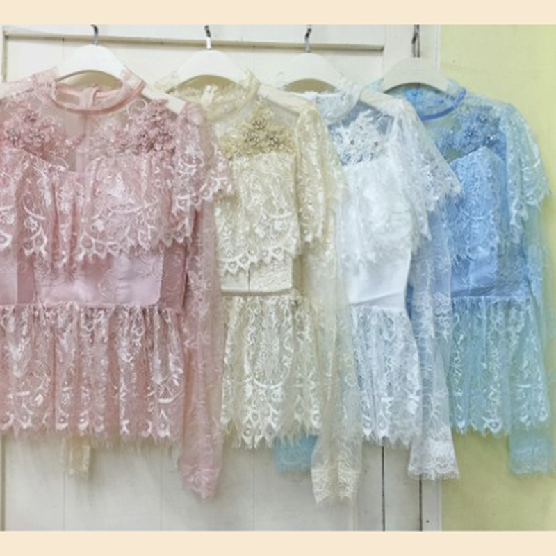 kudapy เสื้อลูกไม้เนื้อนิ่มสีขาว/ชมพู/ครีมทอง/ฟ้า แขนยาว คอปิด ระบายรอบไหล่เย็บแต่งดอกไม้สามมิติช่วงไหล่ด้านหน้า เอวระบายบาน ผ้าลูกไม้นิ่มยืดหยุ่นเนื้อเงา