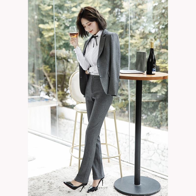 kudapy ชุดสูททำงานสีเทาเข้ม/สีฟ้าคราม แต่งกระดุมคู่พร้อมกางเกง จุดเด่นของชุดนี้คือการออกแบบตัวเสื้อที่เรียบง่ายเป็นแบบปกป้าน