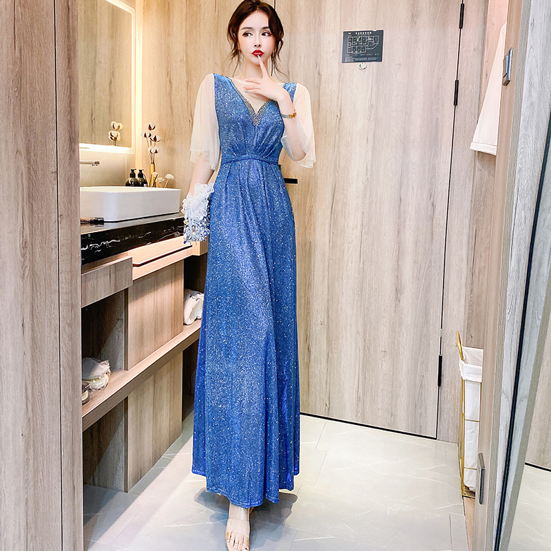 kudapy ชุดราตรียาวสีน้ำเงินเหลือบเขียวปีกแมลงทับ ผ้ากลิสเตอร์ อกเสื้อแต่งด้วยผ้ามุ้งสีครีมเป็นตัววี ประดับดิ้นสีทองที่อกเสื้อติดกับผ้ามุ้ง