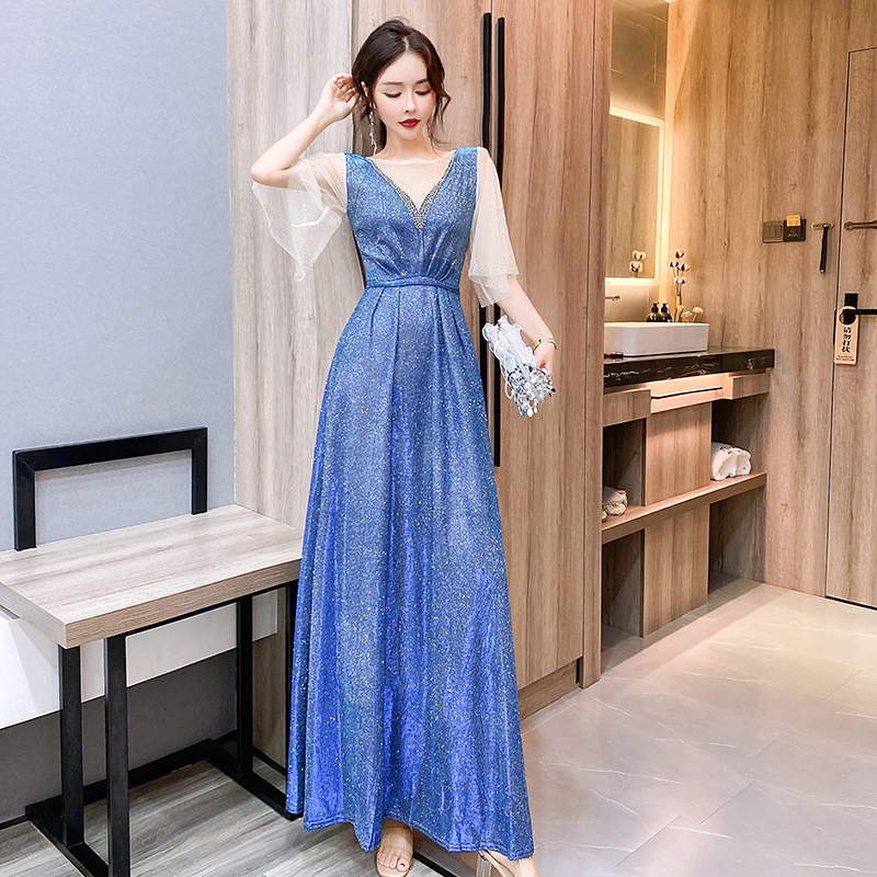 kudapy ชุดราตรียาวสีน้ำเงินเหลือบเขียวปีกแมลงทับ ผ้ากลิสเตอร์ อกเสื้อแต่งด้วยผ้ามุ้งสีครีมเป็นตัววี ประดับดิ้นสีทองที่อกเสื้อติดกับผ้ามุ้ง