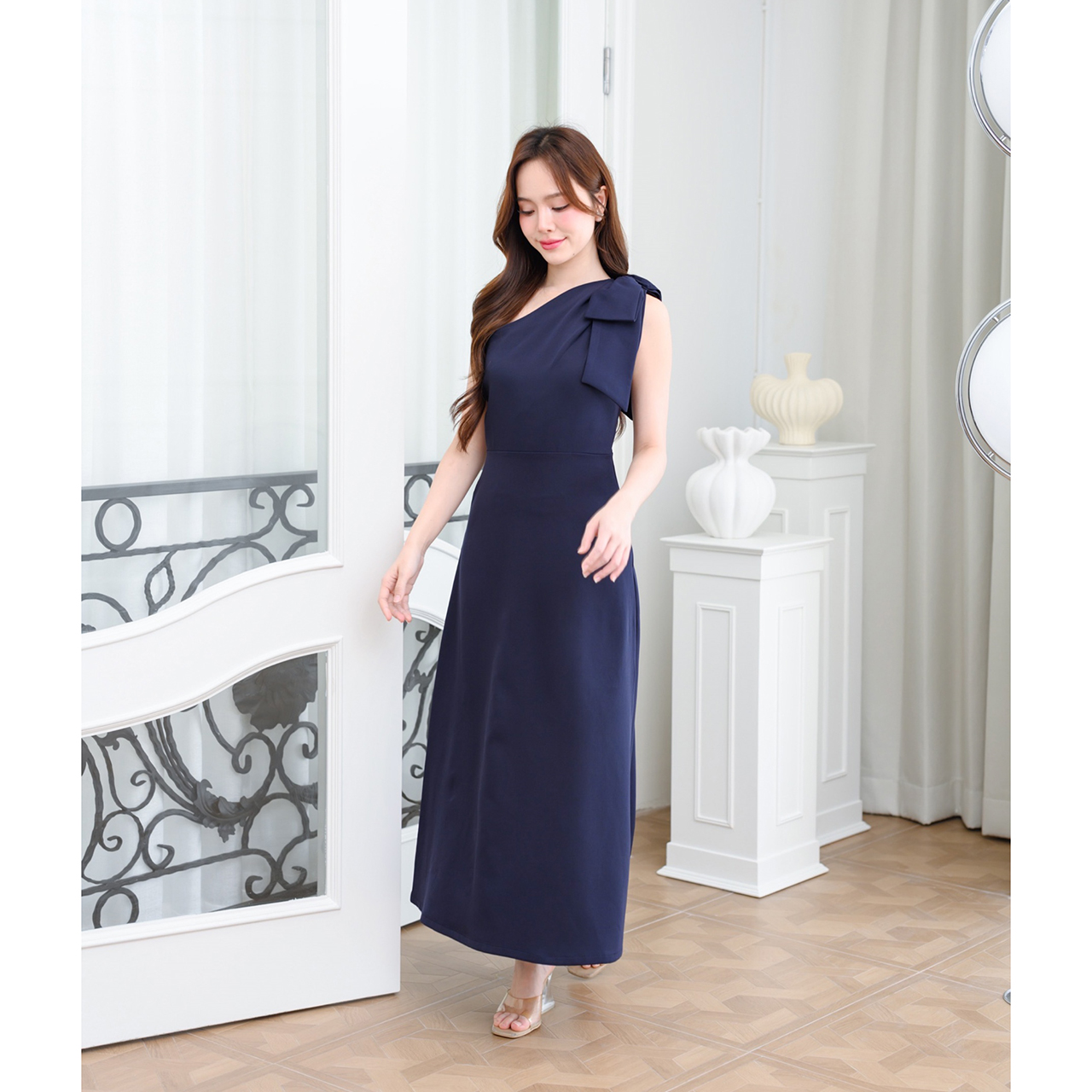 kudapy เดรสยาวสไตล์เรียบหรู ดีไซน์คอเฉีบงปาดไหล่ แต่งด้วยโบว์เพิ่มความน่ารักละมุน ทรงส่วยเข้ารูปพอดีตัว กระโปรงทรงเอยาว