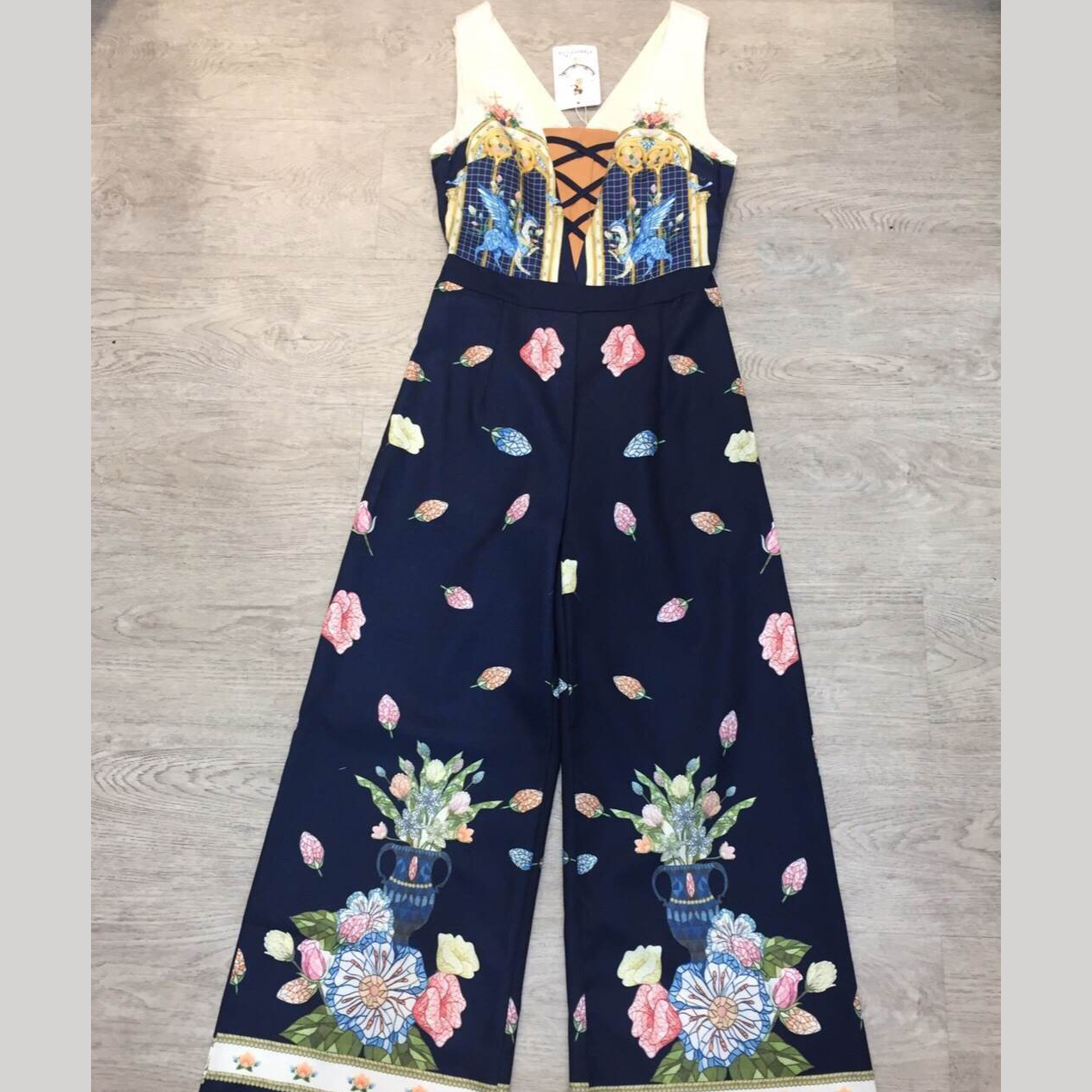 kudapy จั๊มสูทขายาวสีครีมดำ ด้านบนเป็นสีพื้น มีสายไขว้หน้า เนื้อผ้าพิมพ์ลายรอบตัว มีซับในและซิปหลัง