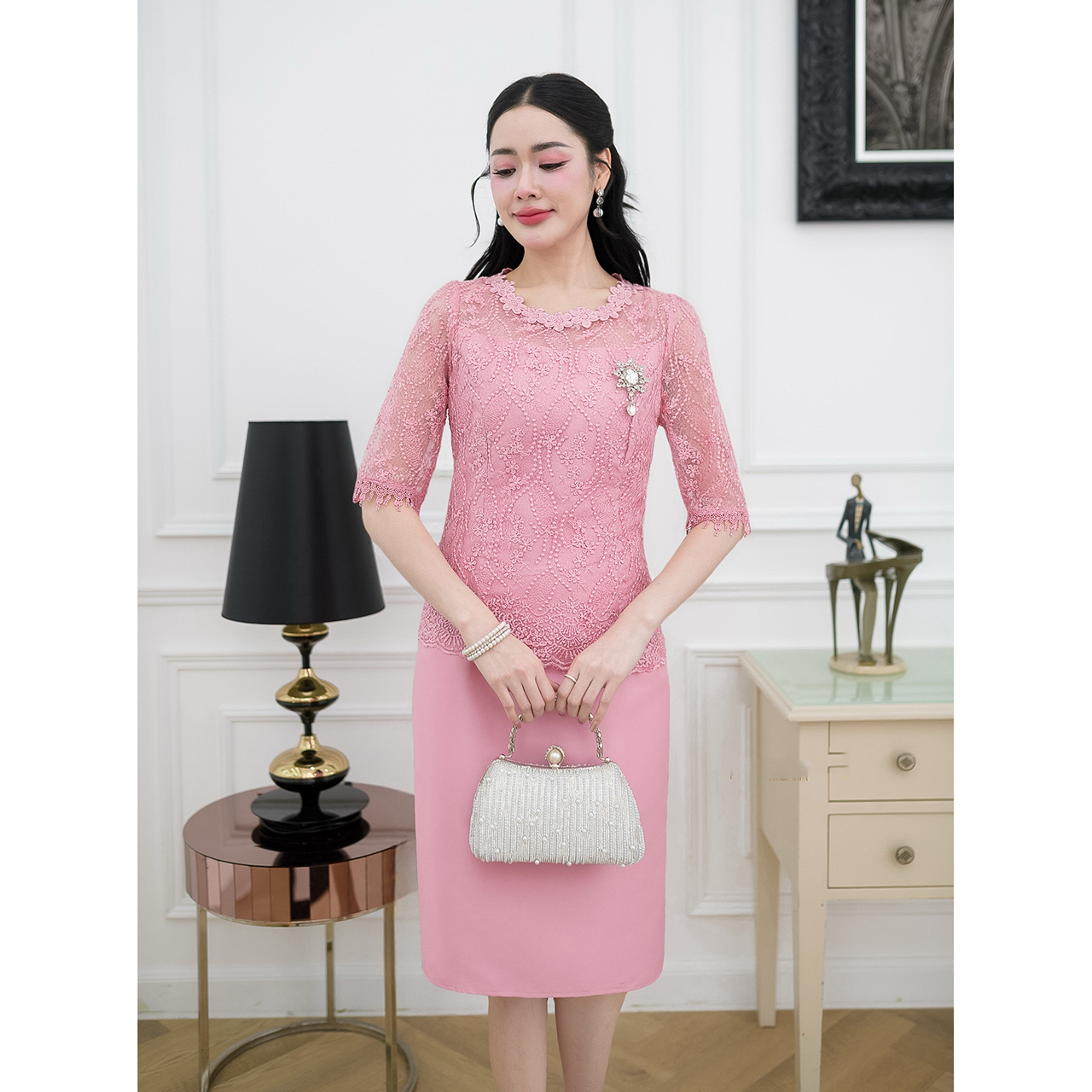 kudapy เดรสผ้าไหมทรงเรียบ ด้านบนเป็นงานผ้าลูกไม้ใยบวบแขนสามส่วนแต่งปลายแขนด้วยลูกไม้ทอลาย ช่วงคอแต่งด้วยลูกไม้ดอกไม้รอบคอ