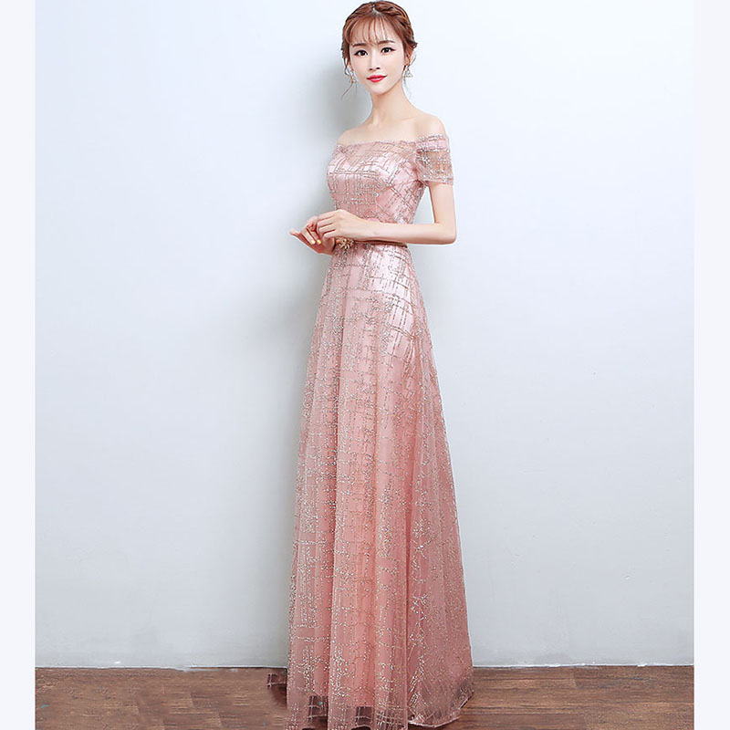 kudapy ชุดราตรียาวสีชมพู แบบไหล่ปาดแขนสั้น แต่งเม็ดกากเพชรทั้งชุด มาพร้อมเข็มขัดรูปใบไม้สีทอง หรูมาก