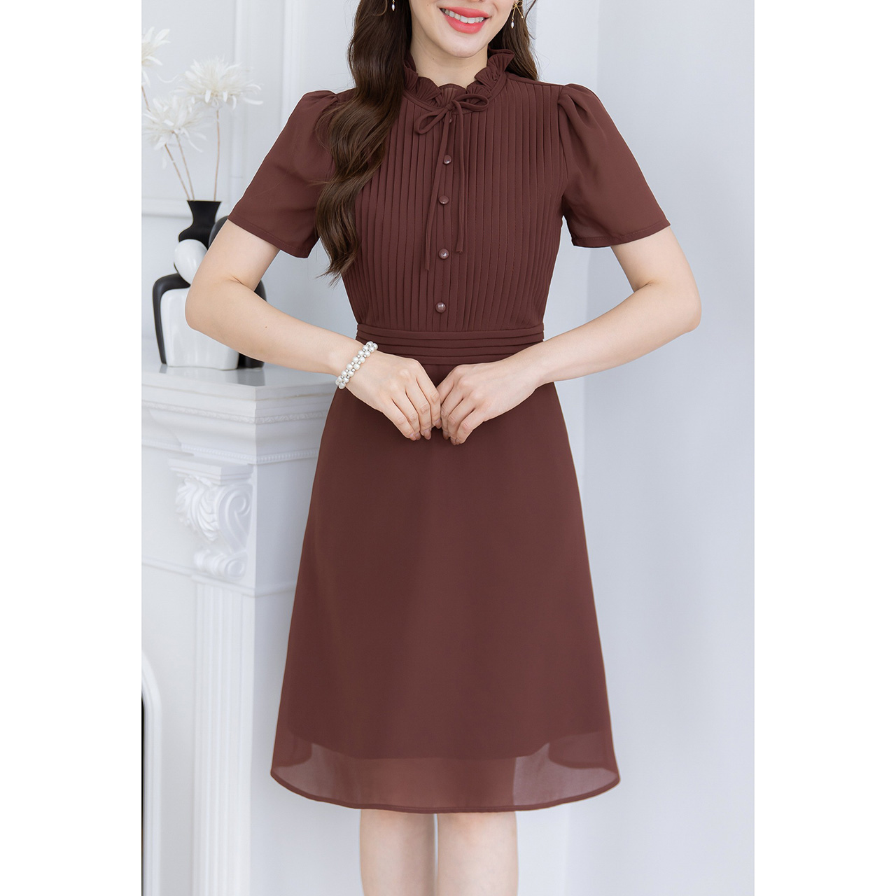 kudapy เดรสผ้าพื้นชีฟอง เย็บเป็นเกล็ดแนวตั้งด้านหน้าและขอบเอวแนวนอน ช่วงคออัดพลีทสวยมีวอลุ่ม แต่งโบว์และแต่งกระดุม