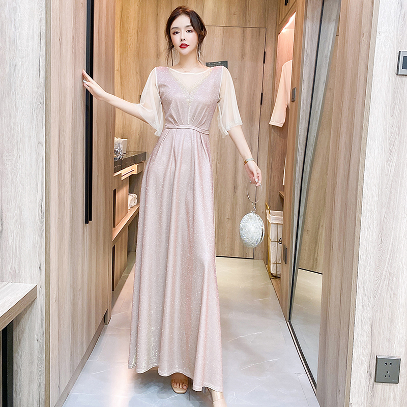 kudapy ชุดราตรียาวสีชมพูอ่อน ผ้ากลิสเตอร์ หน้าอกเสื้อแต่งด้วยผ้ามุ้งสีครีมเป็นตัววี ประดับดิ้นสีทองที่อกเสื้อติดกับผ้ามุ้ง