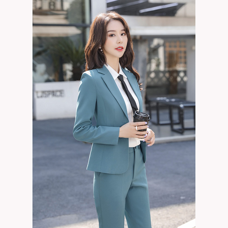 kudapy ชุดสูททำงานสีเทาเข้ม/สีฟ้าคราม แต่งกระดุมคู่พร้อมกางเกง จุดเด่นของชุดนี้คือการออกแบบตัวเสื้อที่เรียบง่ายเป็นแบบปกป้าน