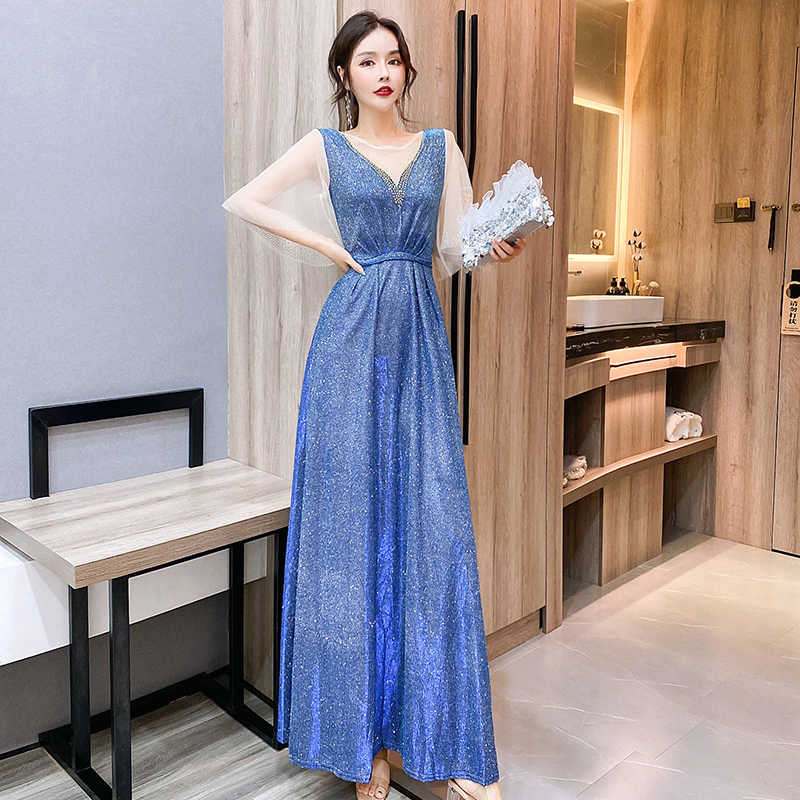 kudapy ชุดราตรียาวสีน้ำเงินเหลือบเขียวปีกแมลงทับ ผ้ากลิสเตอร์ อกเสื้อแต่งด้วยผ้ามุ้งสีครีมเป็นตัววี ประดับดิ้นสีทองที่อกเสื้อติดกับผ้ามุ้ง