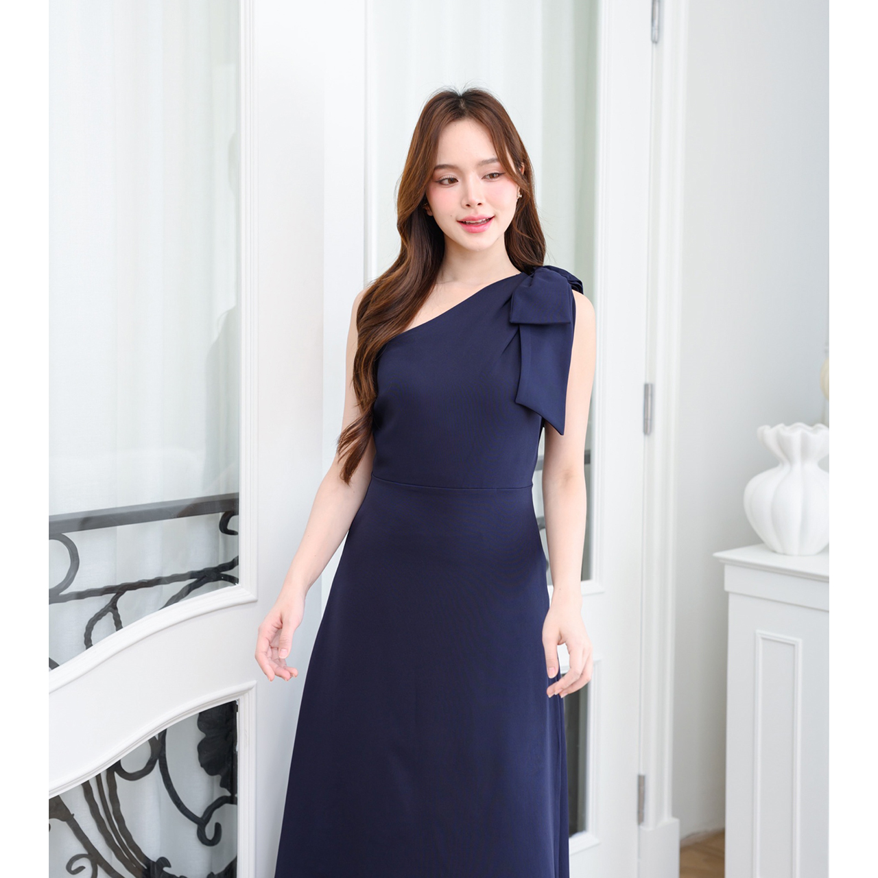 kudapy เดรสยาวสไตล์เรียบหรู ดีไซน์คอเฉีบงปาดไหล่ แต่งด้วยโบว์เพิ่มความน่ารักละมุน ทรงส่วยเข้ารูปพอดีตัว กระโปรงทรงเอยาว