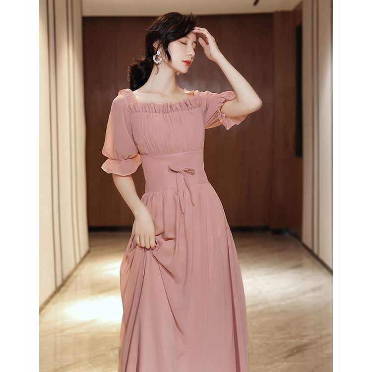 kudapy ชุดเดรสราตรียาว ผ้าชีฟองเนื้อดีสีชมพูนู้ด เดรสเปิดไหล่ หรือปิดไหล่ รอบคอเสื้อมีสายยืดจั๊มด้านใน แขนเสื้อสั้น ปลายแขนจั๊ม เย็บแต่งโบว์ที่เอวด้านหน้า