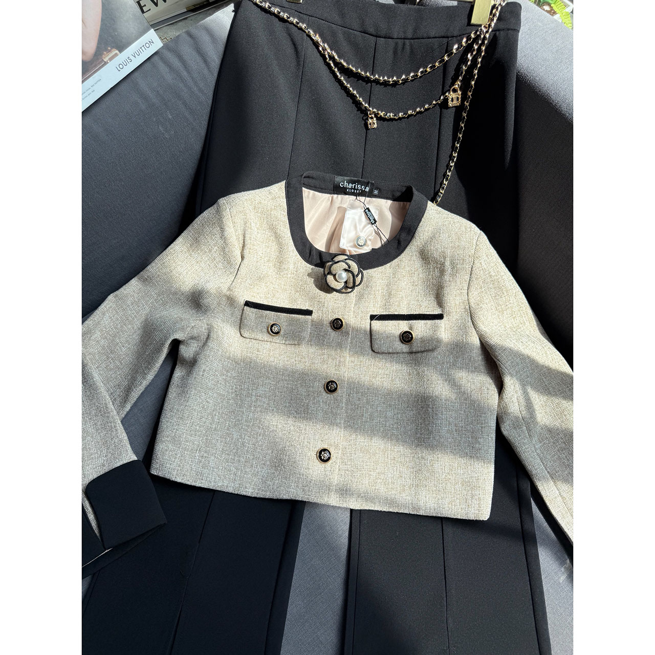 kudapy เซ็ทเสื้อครอปสูท ผ้าเนื้อทอแน่นสีสวยคลาสสิก ตัดต่อขอบสีดำบริเวณคอ แขน และชายเสื้อ เพิ่มความคมชัด กระดุมหน้าเรียงแนวตั้งแบบมินิมอล