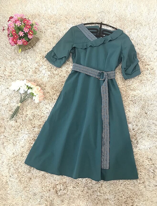 เดรสสั้นสีเขียว คอปาดกว้าง ผ้าคอตตอนผสม แต่งคอเสื้อข้างขวาลายเดียว มีเข็มขัดผูกเอวตามแบบ