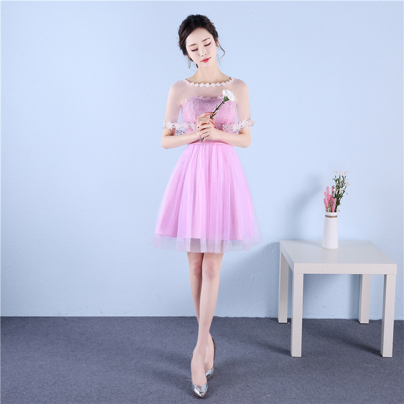 kudapy ชุดราตรีสั้นสีชมพู มีผ้าคลุมไหล่ ช่วงบนผ้าลูกไม้ ช่วงล่างเป็นผ้าซีทรู เอวสม็อคหลังยืดได้ตามตัว