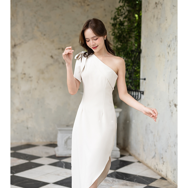 kudapy เดรสยาวสีชมพู/สีครีม/สีน้ำตาลอมส้ม ช่วงบนเป็นแบบปาดไหล่ข้างเดียวแต่งผ้าพับอก มีสายผูกโบว์ที่ไหล่ด้านขวาเพิ่มความหวาน เป็นกระโปรงทรงสอบ กระโปรงชายเฉียงเพิ่มความสวยชิค