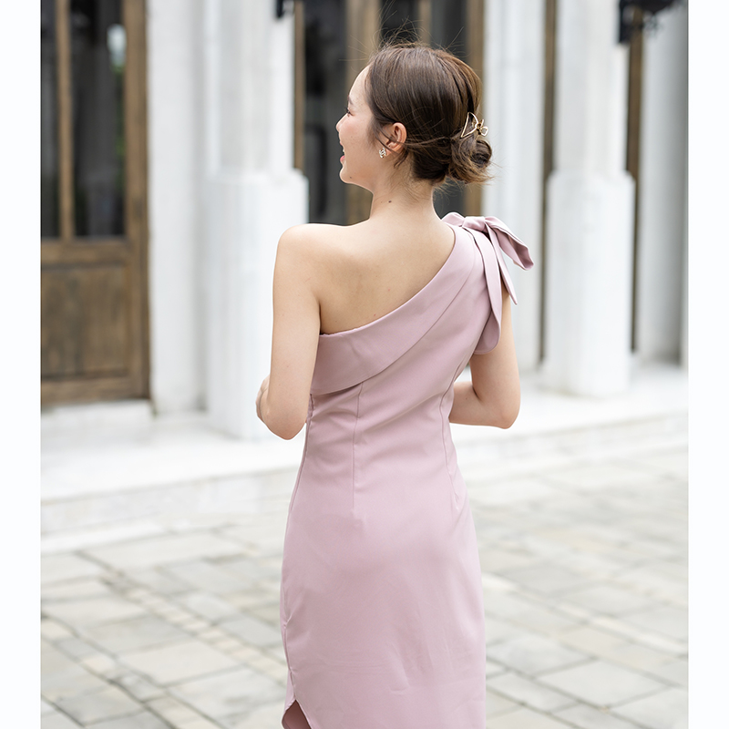 kudapy เดรสยาวสีชมพู/สีครีม/สีน้ำตาลอมส้ม ช่วงบนเป็นแบบปาดไหล่ข้างเดียวแต่งผ้าพับอก มีสายผูกโบว์ที่ไหล่ด้านขวาเพิ่มความหวาน เป็นกระโปรงทรงสอบ กระโปรงชายเฉียงเพิ่มความสวยชิค