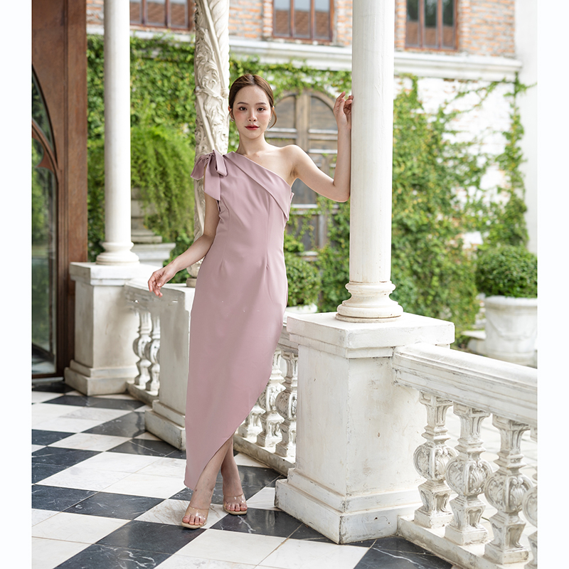 kudapy เดรสยาวสีชมพู/สีครีม/สีน้ำตาลอมส้ม ช่วงบนเป็นแบบปาดไหล่ข้างเดียวแต่งผ้าพับอก มีสายผูกโบว์ที่ไหล่ด้านขวาเพิ่มความหวาน เป็นกระโปรงทรงสอบ กระโปรงชายเฉียงเพิ่มความสวยชิค