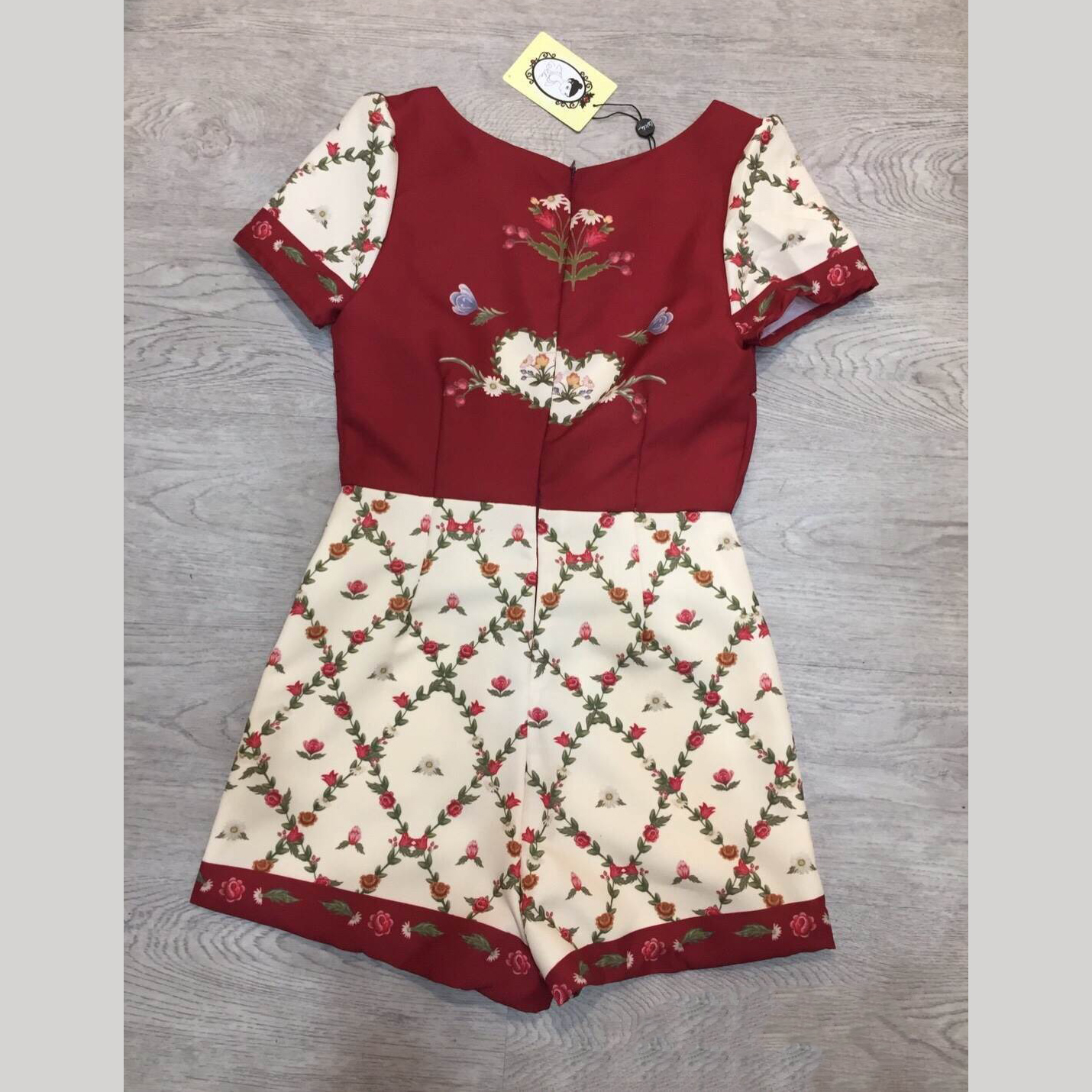 kudapy จั้มสูทขาสั้นสีแดงพิมพ์ลาย คอกลมแขนสั้น เนื้อผ้าพิมพ์ลายรอบตัว มีกระเป๋าข้าง และมีซับในและซิปหลัง