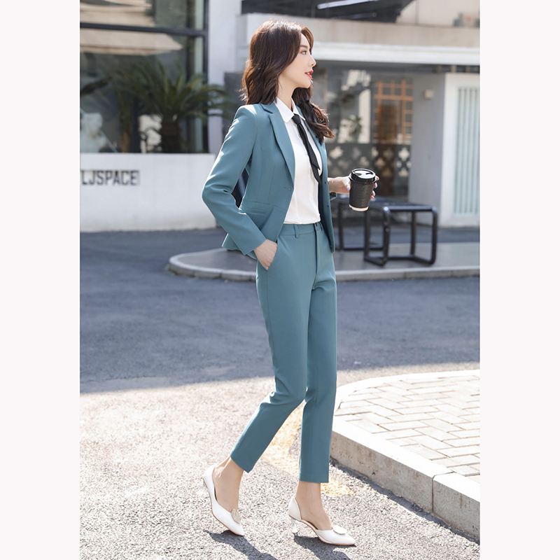 kudapy ชุดสูททำงานสีเทาเข้ม/สีฟ้าคราม แต่งกระดุมคู่พร้อมกางเกง จุดเด่นของชุดนี้คือการออกแบบตัวเสื้อที่เรียบง่ายเป็นแบบปกป้าน