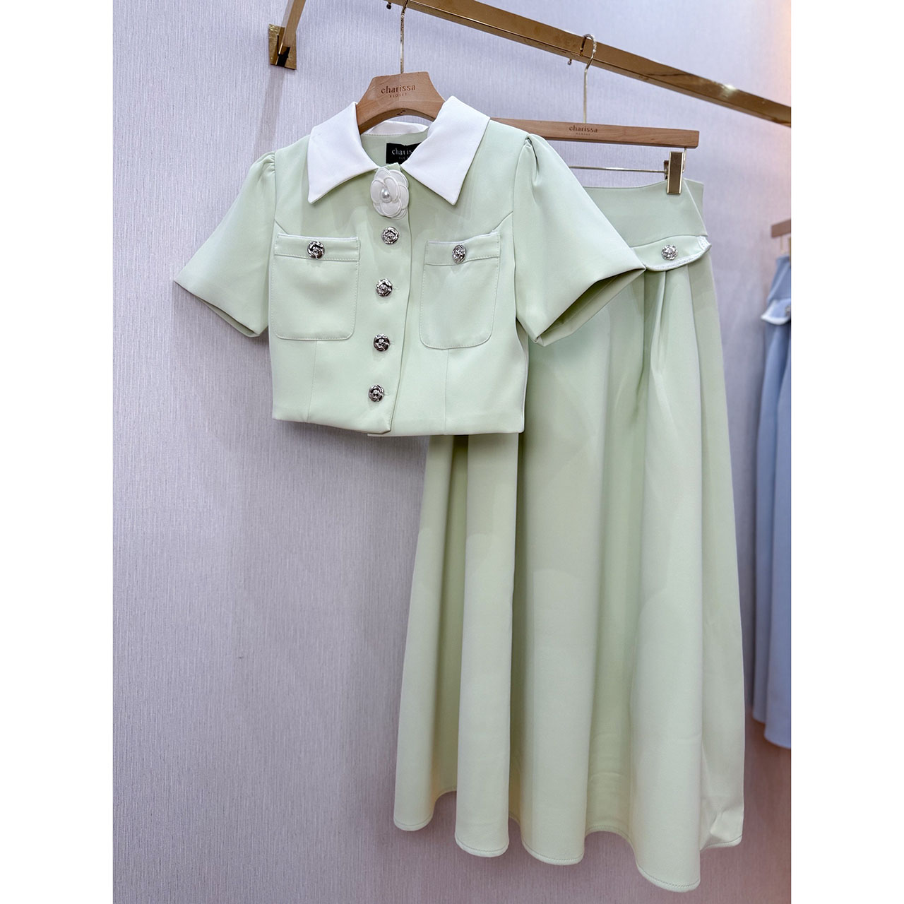 kudapy ชุดเซ็ทเสื้อทรงครอป กระดุมจริงรูปดอกไม้สีเงิน แต่งปกสีขาว มาพร้อมกับกระโปรงยาวซิปหลัง แต่งกระเป๋าหลอกด้านหน้า