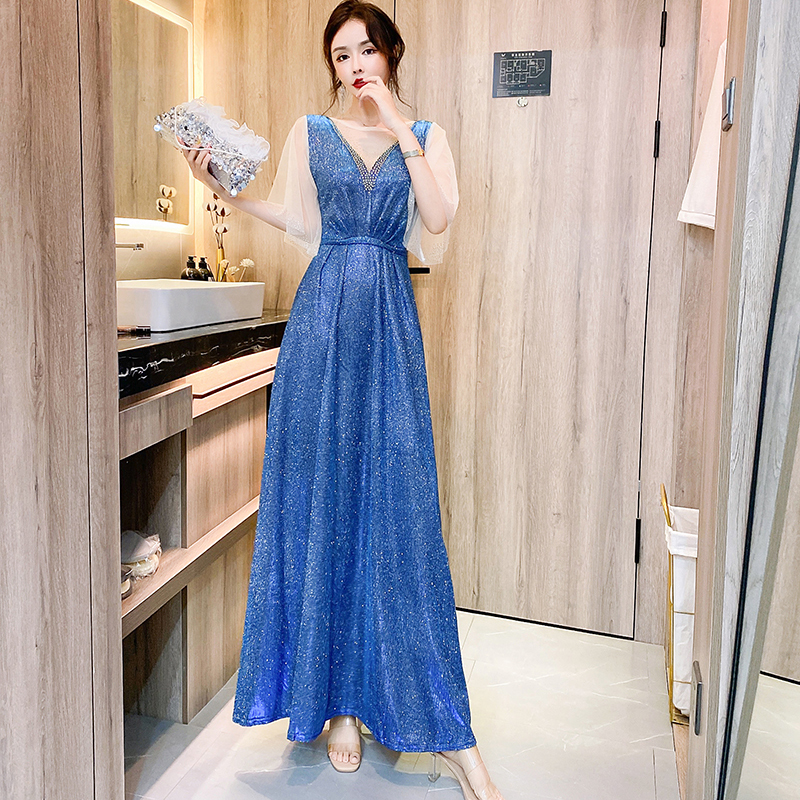 kudapy ชุดราตรียาวสีน้ำเงินเหลือบเขียวปีกแมลงทับ ผ้ากลิสเตอร์ อกเสื้อแต่งด้วยผ้ามุ้งสีครีมเป็นตัววี ประดับดิ้นสีทองที่อกเสื้อติดกับผ้ามุ้ง