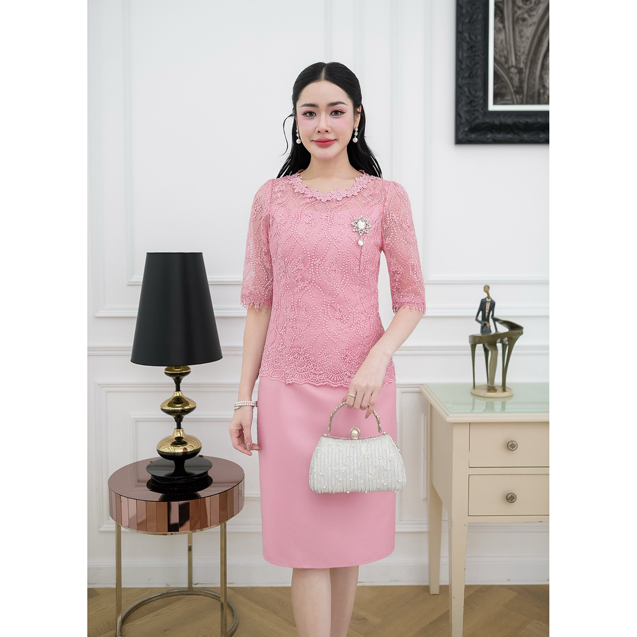 kudapy เดรสผ้าไหมทรงเรียบ ด้านบนเป็นงานผ้าลูกไม้ใยบวบแขนสามส่วนแต่งปลายแขนด้วยลูกไม้ทอลาย ช่วงคอแต่งด้วยลูกไม้ดอกไม้รอบคอ