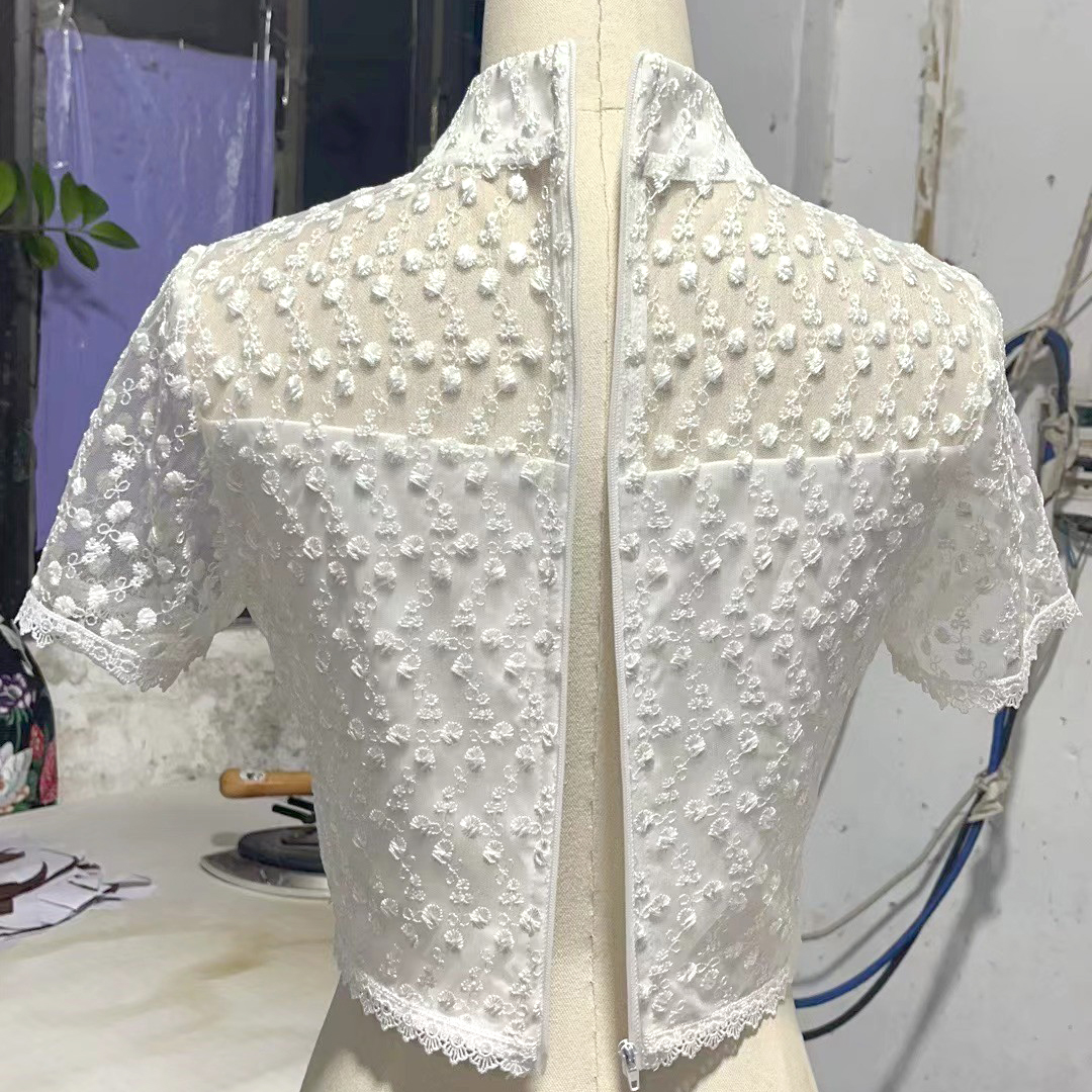 kudapy เสื้อลูกไม้สีขาวปัก 3D ดอกลอย ยกนูน สวยมาก คอจีน แต่งมุขเรียงยาวถึงชายเสื้อ ซับใน 2 ชั้น อย่างดี