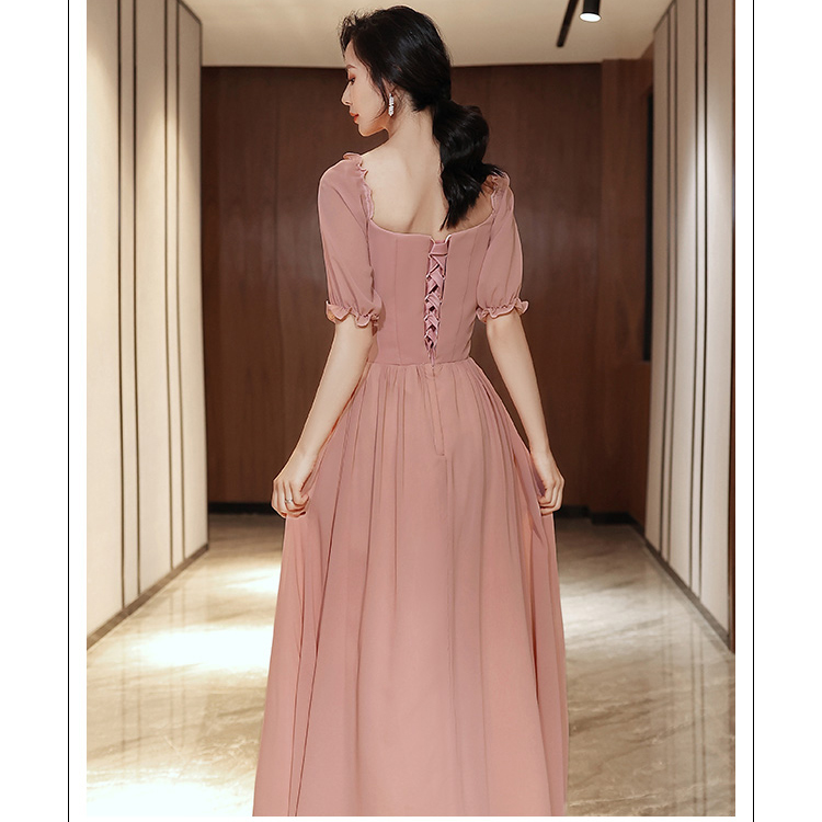 kudapy ชุดเดรสราตรียาว ผ้าชีฟองเนื้อดีสีชมพูนู้ด เดรสเปิดไหล่ หรือปิดไหล่ รอบคอเสื้อมีสายยืดจั๊มด้านใน แขนเสื้อสั้น ปลายแขนจั๊ม เย็บแต่งโบว์ที่เอวด้านหน้า