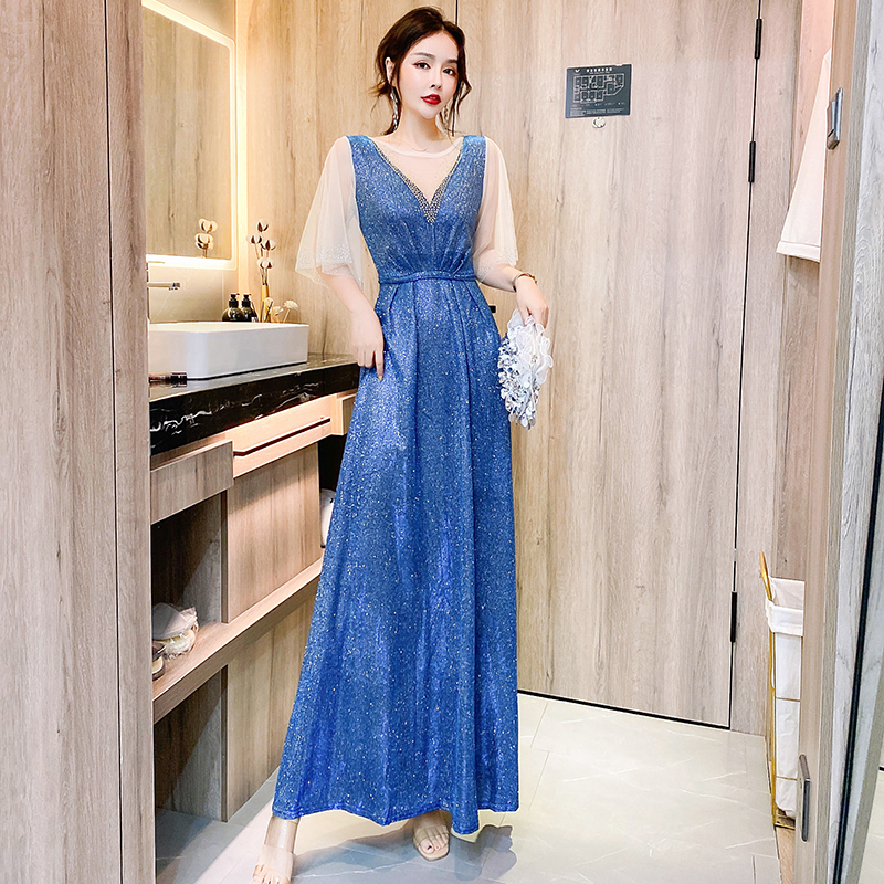 kudapy ชุดราตรียาวสีน้ำเงินเหลือบเขียวปีกแมลงทับ ผ้ากลิสเตอร์ อกเสื้อแต่งด้วยผ้ามุ้งสีครีมเป็นตัววี ประดับดิ้นสีทองที่อกเสื้อติดกับผ้ามุ้ง