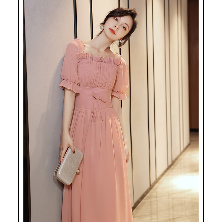 kudapy ชุดเดรสราตรียาว ผ้าชีฟองเนื้อดีสีชมพูนู้ด เดรสเปิดไหล่ หรือปิดไหล่ รอบคอเสื้อมีสายยืดจั๊มด้านใน แขนเสื้อสั้น ปลายแขนจั๊ม เย็บแต่งโบว์ที่เอวด้านหน้า